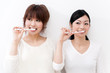 two beautiful asian women blushing her teeth