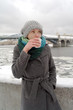 The young white frozen girl drinks hot tea in the winter