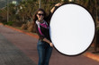 Young woman holding a blank sign on the street