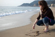 A heart draw in the sand is erased by the waves.