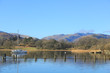 Boat on Windermere with reflection on clear spring day