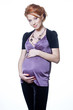 Beautiful redhead pregnant woman holding her belly.