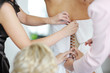 Helping the bride to put her wedding dress on
