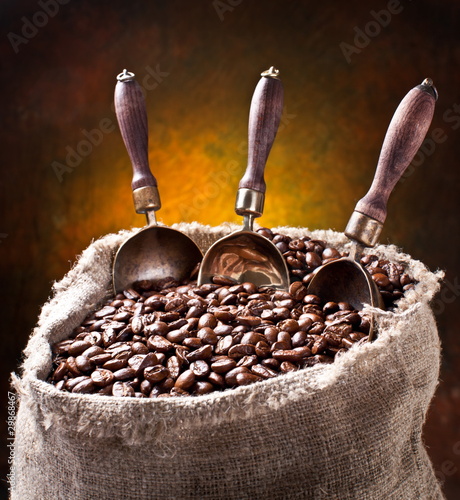 Photo: Sack of coffee beans and scoop. On a dark background. Sack of coffee beans and scoop. On a dark background.