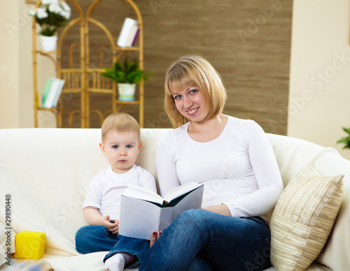 Photo: little boy and his mother at home reading a book little boy and his mother at home reading a book