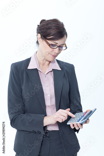 Photo: Businesswoman using pocket calculator Businesswoman using pocket calculator