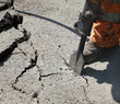 Jackhammer demolishing asphalt at construction site