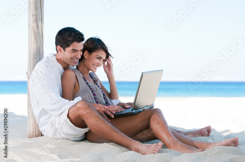 Foto: Summer couple using laptop Summer couple using laptop
