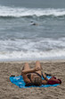 Lady in bikin reading with background of waves and surfer Lady in bikin reading with background of waves and surfer