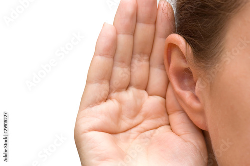 Photo: Girl listening with her hand on an ear Girl listening with her hand on an ear