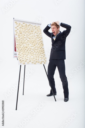 Foto: Screaming businessman standing at flipchart with abundance of post-its Screaming businessman standing at flipchart with abundance of post-its