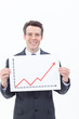Smiling businessman holding ascending line chart