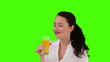 Dark-haired woman drinking orange juice