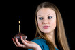 Beautiful girl holding a celebratory muffin with a candle