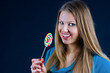 Beautiful girl holding a candy on a stick in his hand