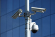 Photo: three security cameras on front of glass building three security cameras on front of glass building