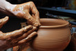 hands of a potter, creating an earthen jar on the circle