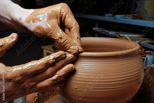 Photo: hands of a potter, creating an earthen jar on the circle hands of a potter, creating an earthen jar on the circle