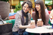 Two beautiful women drinking coffee and chatting