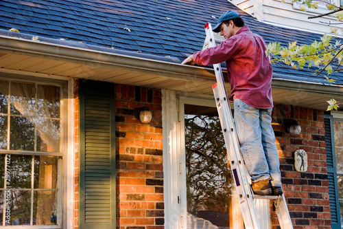 Photo: Man Cleaning Gutters Man Cleaning Gutters
