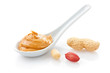Creamy peanut butter in a white spoon with peanuts Creamy peanut butter in a white spoon with peanuts