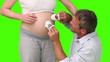 Man touching the belly of his pregnant wife with baby shoes