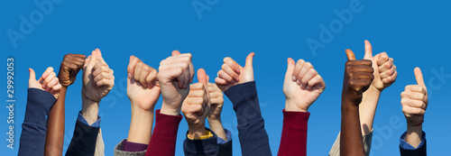Photo: Multiracial Thumbs Up Against Blue Sky Multiracial Thumbs Up Against Blue Sky