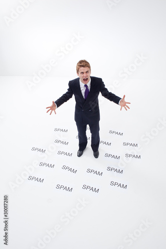 Photo: Angry businessman surrounded by spam Angry businessman surrounded by spam