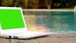 Laptop with green screen near to swimming pool