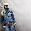 portrait of stylish casual girl with sunglasses in front of a w