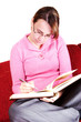 Casual young woman writing in a book