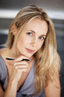 Beautiful young woman holding a pen