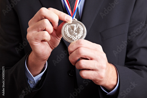 Photo: Hände halten Silbermedaille Hände halten Silbermedaille