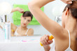 Young beautiful caucasian woman using deodorant
