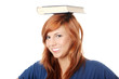 Caucasian woman (student) with book on her head