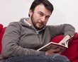 Photo: Portrait of Young Adult Relaxing and Reading a Book at Home Portrait of Young Adult Relaxing and Reading a Book at Home