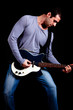 Young man playing guitar isolated on black
