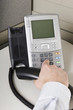 Office worker placing a call on an IP phone Office worker placing a call on an IP phone