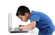 Photo: Cute child working on computer isolated on white background. Cute child working on computer isolated on white background.