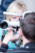 optometry concept - pretty young female patient having her eyes