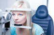 optometry concept - pretty young female patient having her eyes