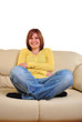 Foto: eine junge Frau sitzt entspannt auf einer Couch eine junge Frau sitzt entspannt auf einer Couch