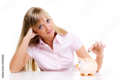 Photo: blonde frau wirft geld ins sparschwein blonde frau wirft geld ins sparschwein
