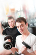Two guys lifting heavy dumbbells in sportclub Two guys lifting heavy dumbbells in sportclub