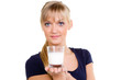 hübsche junge frau zeigt ein glas milch