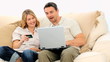 Pretty young couple using a credit card on internet