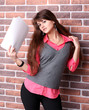 Smiling young business woman with document over brickwall