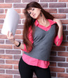 Smiling young business woman with document over brickwall