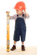 Little builder with liquid level, standing on wood floor