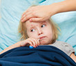 a mother measures the temperature of her sick daughter